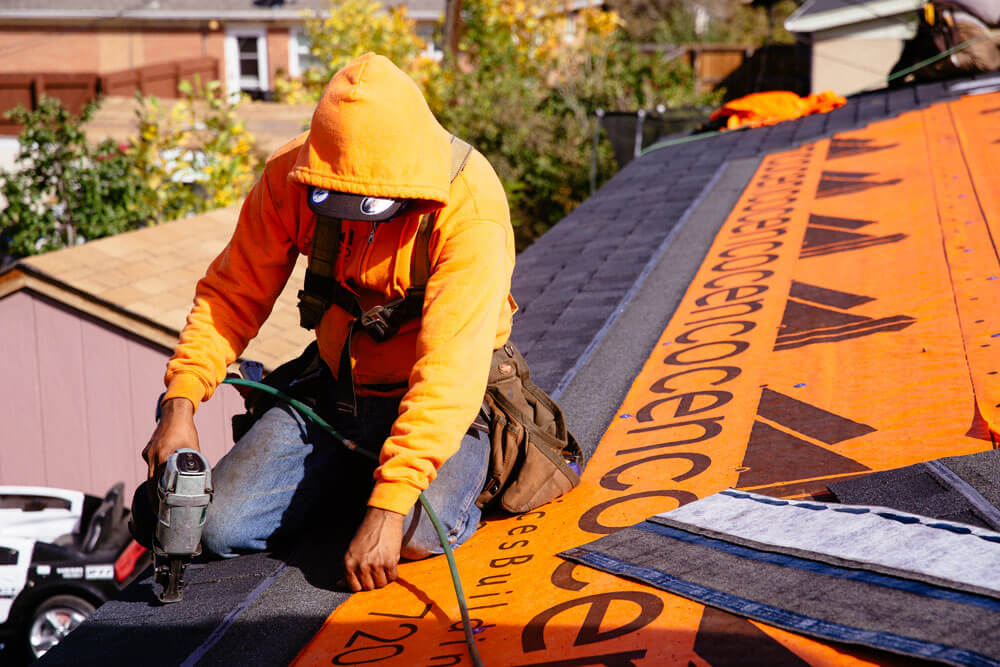 worker applying roofing tiles